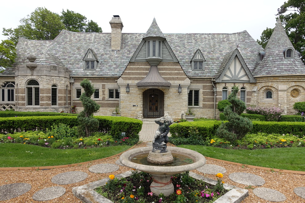 Example of a classic one-story stone gable roof design in Chicago
