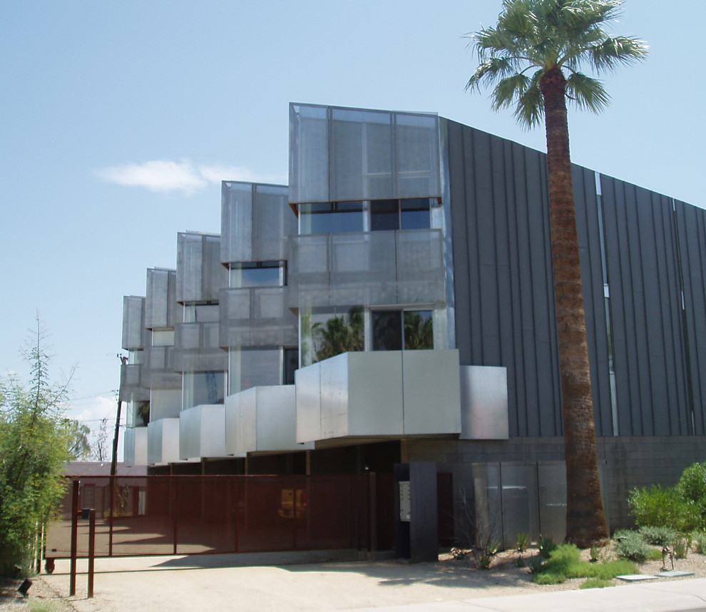 Idee per la facciata di un appartamento grigio moderno a due piani di medie dimensioni con rivestimento con lastre in cemento, tetto piano e copertura in metallo o lamiera
