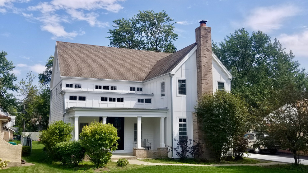 Cette photo montre une grande façade de maison blanche moderne en panneau de béton fibré à deux étages et plus avec un toit à deux pans et un toit en shingle.