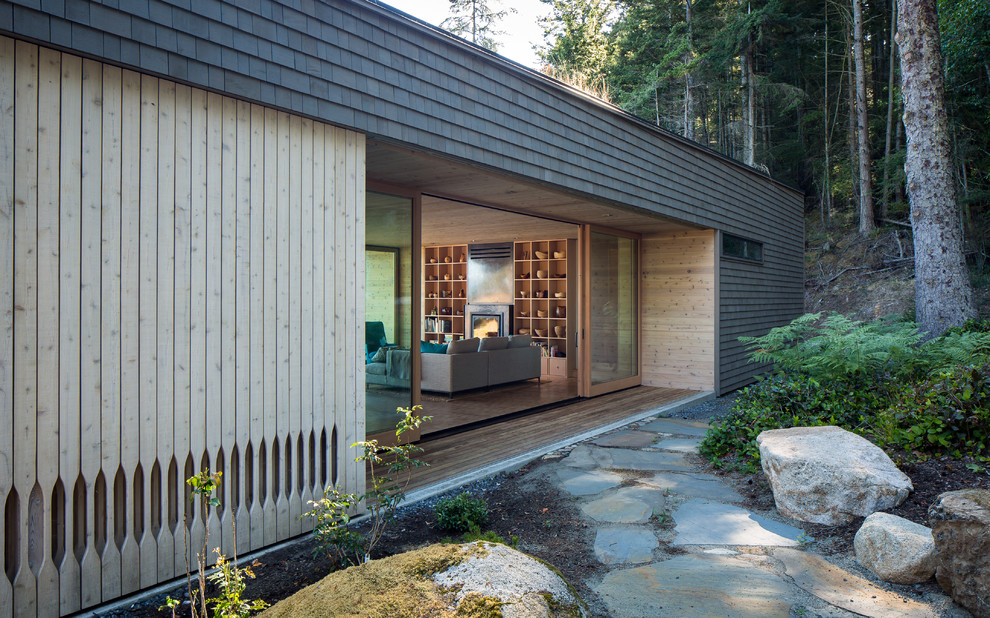 Diseño de fachada gris moderna de tamaño medio de una planta con revestimiento de madera y tejado plano