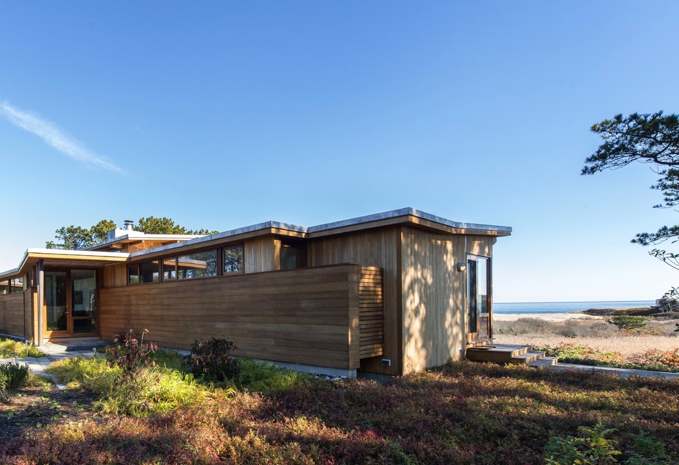 Inspiration pour une façade de maison marron minimaliste en bois de taille moyenne et de plain-pied avec un toit plat.