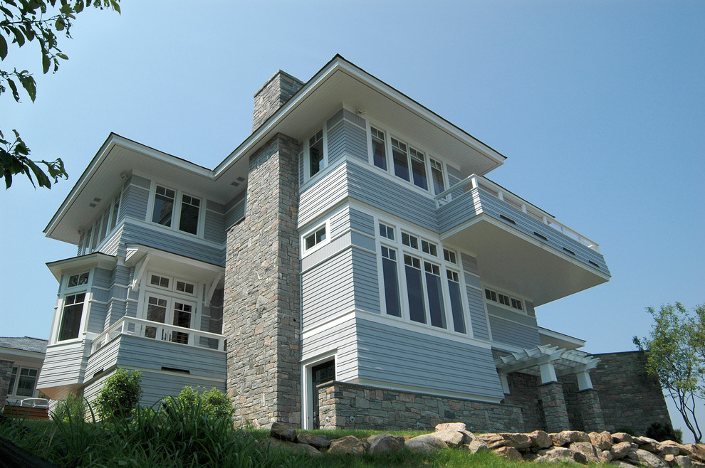 Immagine della facciata di una casa ampia blu contemporanea a due piani con rivestimento con lastre in cemento e tetto a padiglione