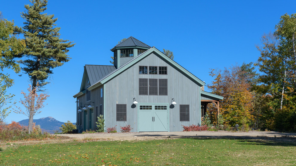 Imagen de fachada de casa gris campestre con revestimiento de madera, tejado a dos aguas y tejado de metal
