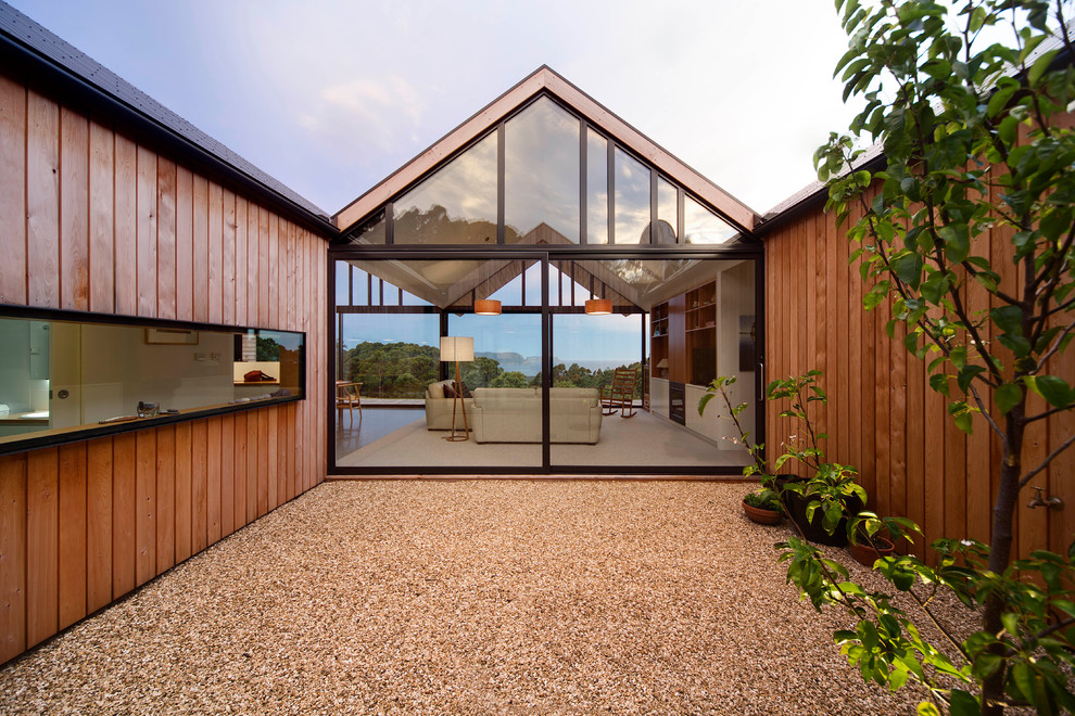 Ispirazione per la facciata di una casa grande marrone contemporanea a un piano con rivestimento in legno e tetto a capanna