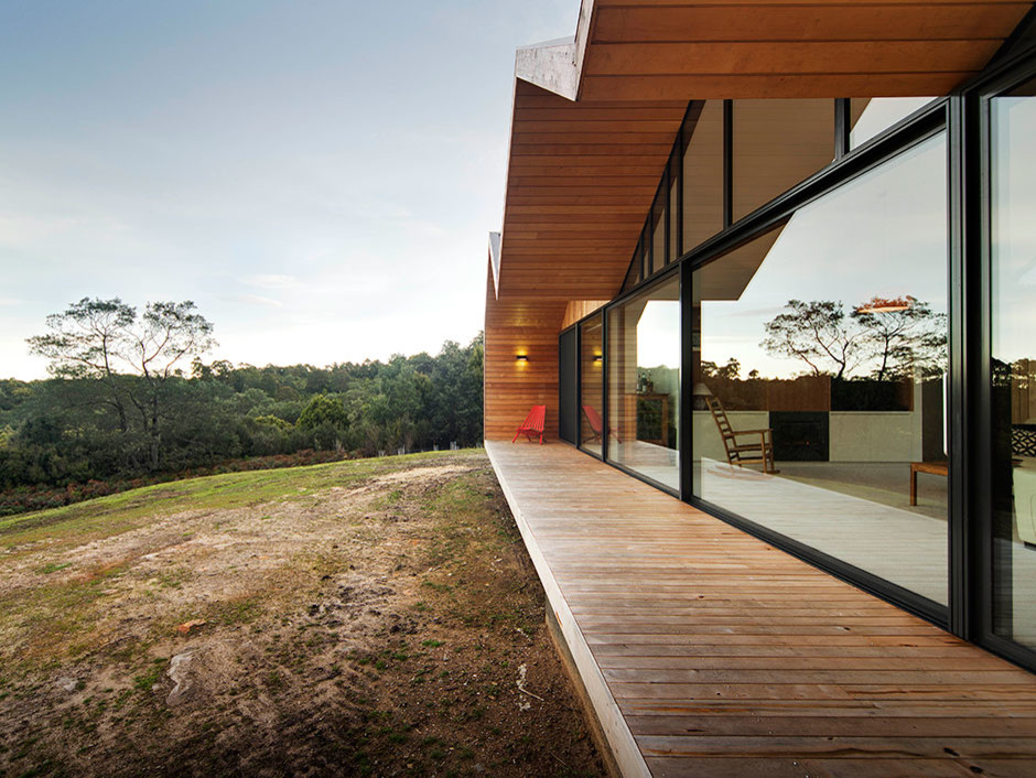 Idée de décoration pour une grande façade de maison marron design en bois de plain-pied avec un toit à deux pans.