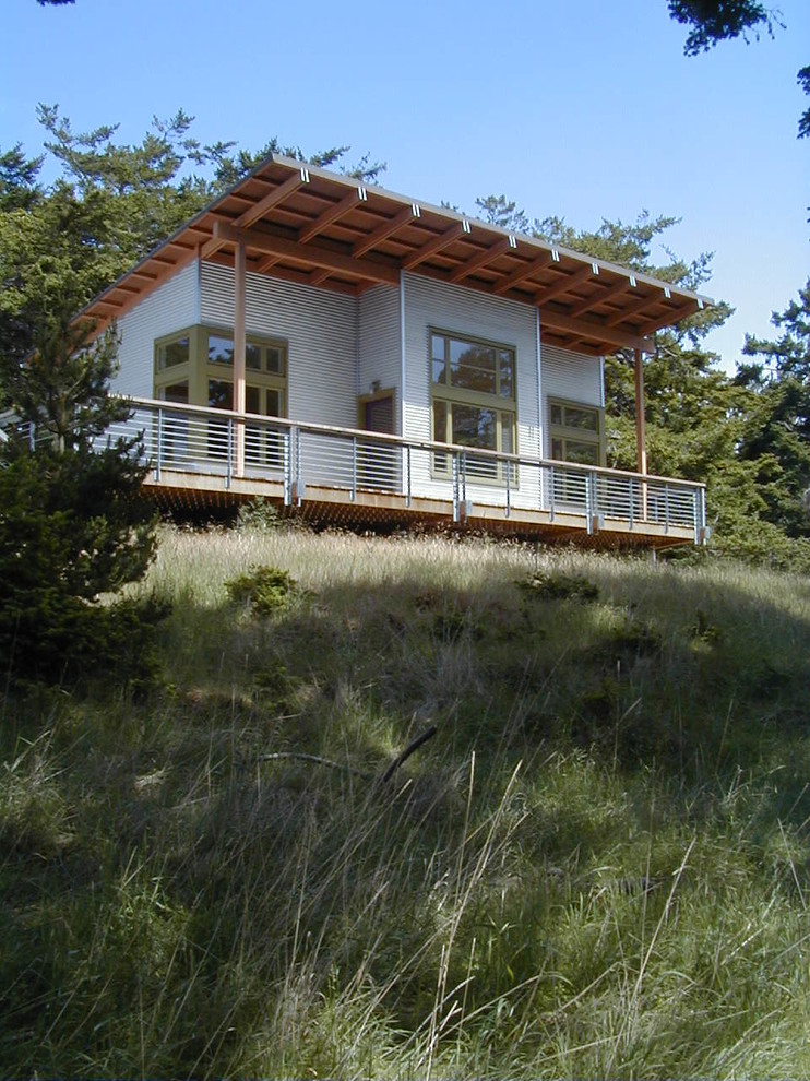 Exempel på ett modernt hus, med metallfasad och pulpettak