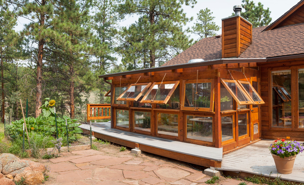 This is an example of a rustic house exterior in Denver with wood cladding.