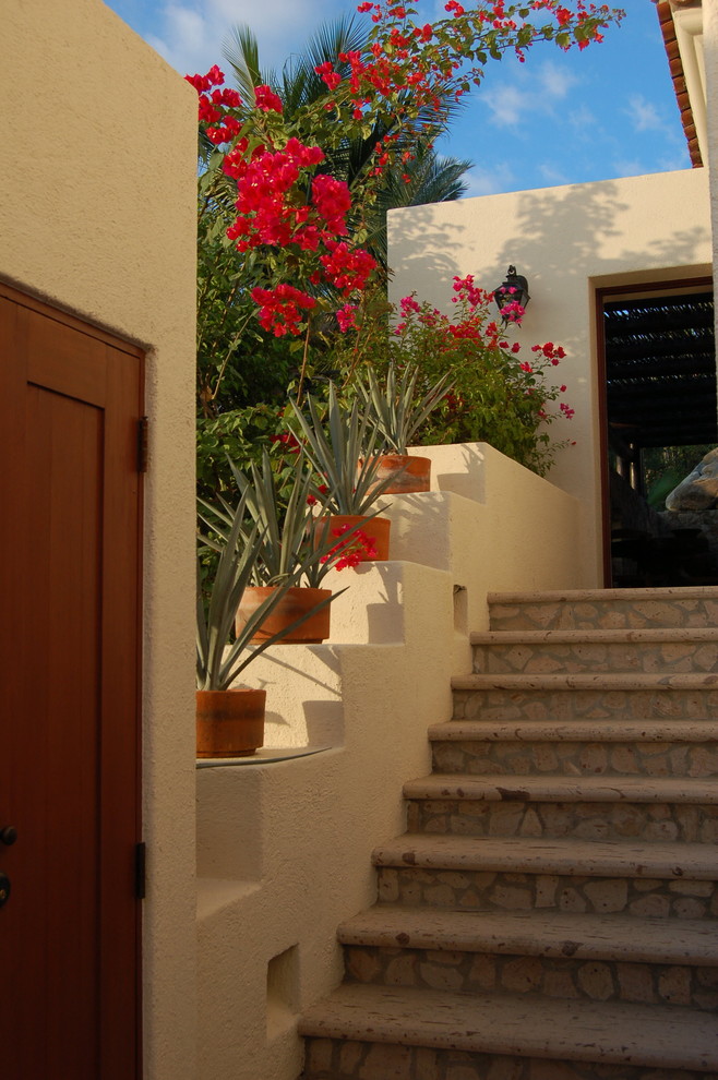 Пример оригинального дизайна: двухэтажный, белый дом среднего размера в средиземноморском стиле с облицовкой из цементной штукатурки