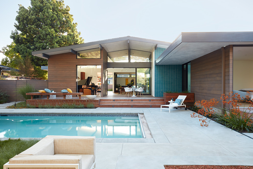 Cette image montre une façade de maison multicolore vintage de plain-pied avec un revêtement mixte et un toit à deux pans.