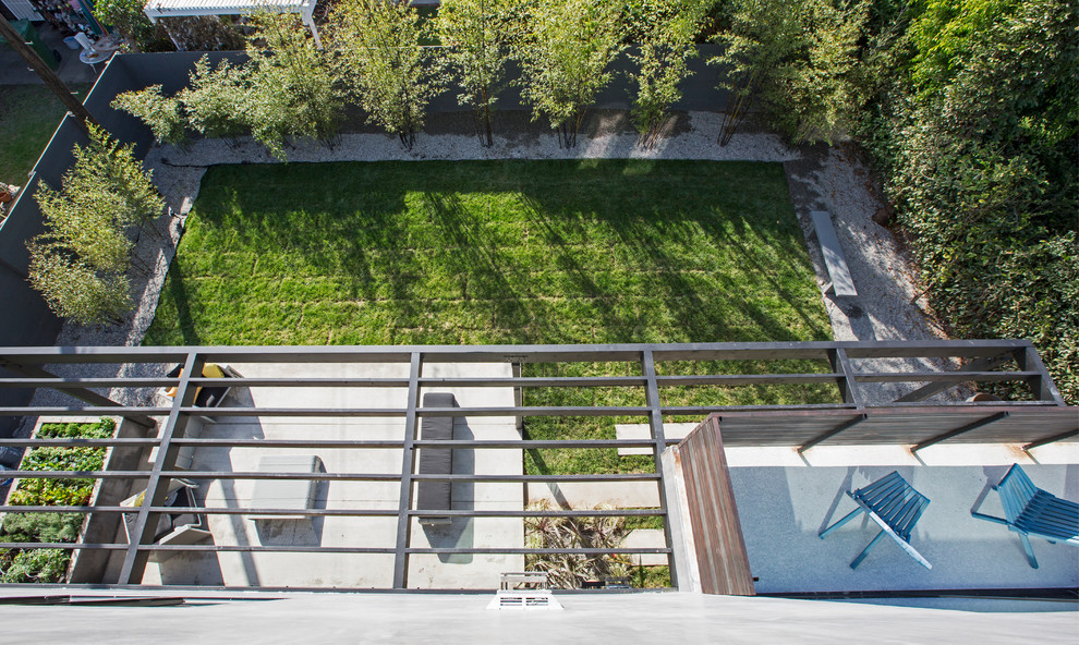 Réalisation d'une façade de maison grise design à un étage avec un toit plat.