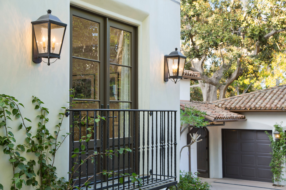 Inspiration for a mediterranean white two-story stucco gable roof remodel in Los Angeles