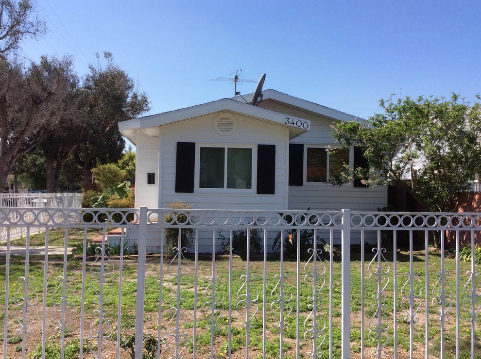 Cette photo montre une petite façade de maison blanche chic de plain-pied avec un revêtement en vinyle et un toit à deux pans.