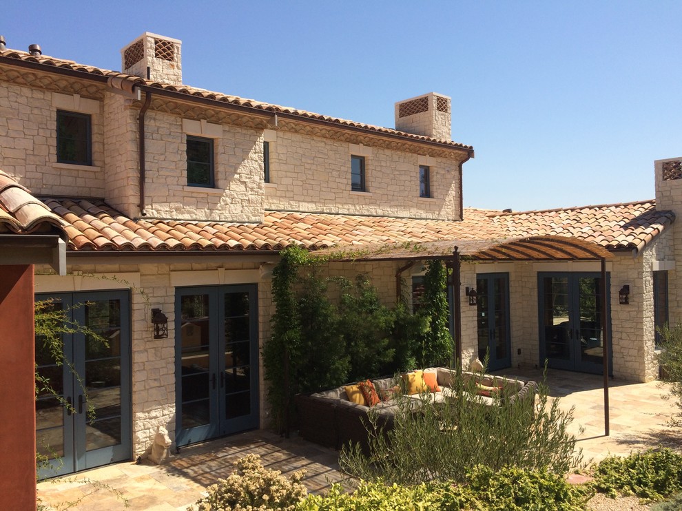 Imagen de fachada de casa beige de estilo americano grande de dos plantas con revestimiento de piedra, tejado a dos aguas y tejado de teja de barro