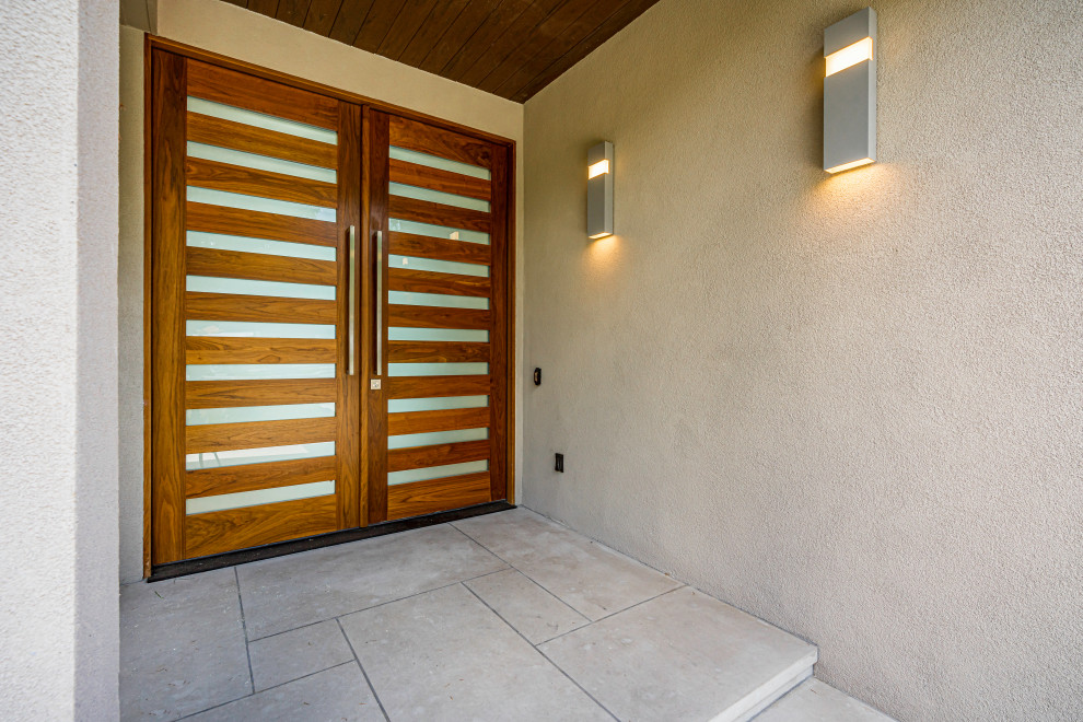 Immagine della villa beige moderna a piani sfalsati con rivestimento in stucco