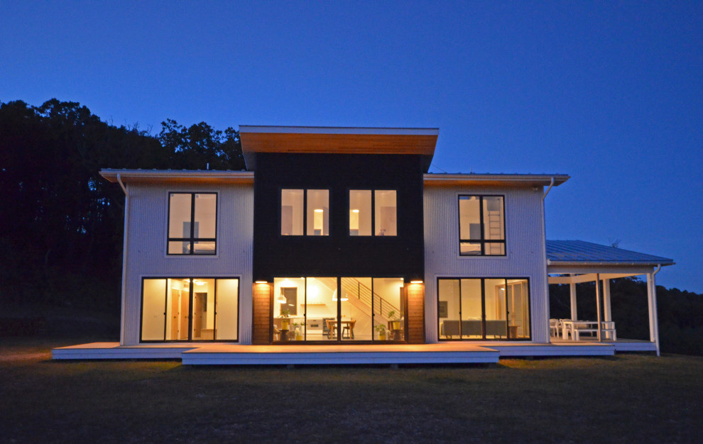 Mittelgroßes, Zweistöckiges Modernes Einfamilienhaus mit Metallfassade, Schmetterlingsdach, Blechdach, grauem Dach, Verschalung und weißer Fassadenfarbe in Sonstige