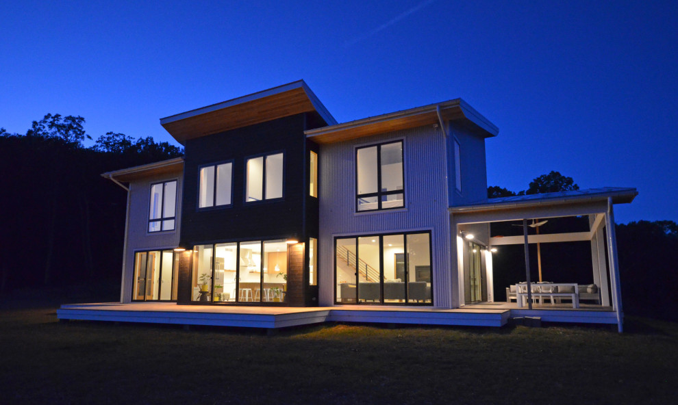 Example of a mid-sized trendy white two-story metal and clapboard house exterior design in Other with a butterfly roof, a metal roof and a gray roof