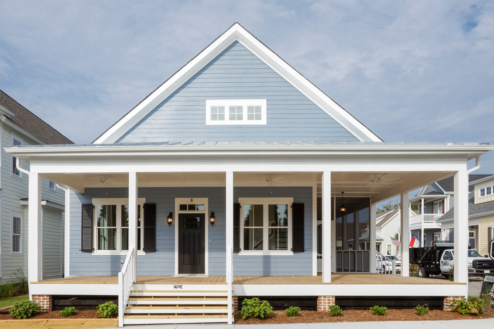 Réalisation d'une grande façade de maison bleue champêtre en panneau de béton fibré à un étage avec un toit à deux pans et un toit en shingle.