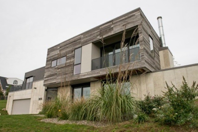 Idée de décoration pour une grande façade de maison grise design à un étage avec un revêtement mixte et un toit plat.