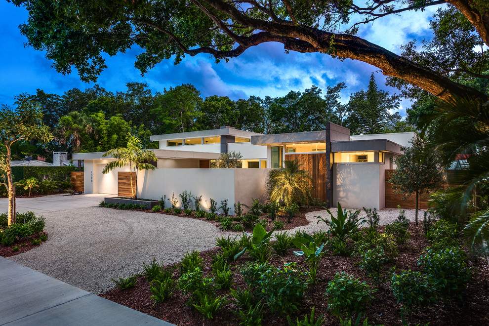 Large 1960s white one-story stucco exterior home idea in Other