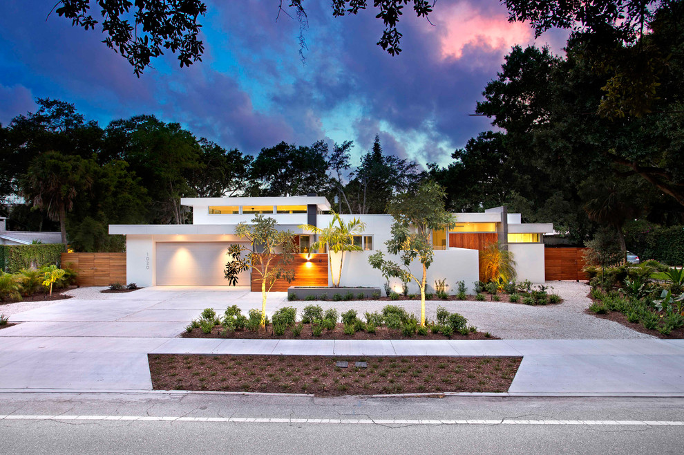 Стильный дизайн: одноэтажный, белый частный загородный дом среднего размера в стиле модернизм с облицовкой из цементной штукатурки и плоской крышей - последний тренд