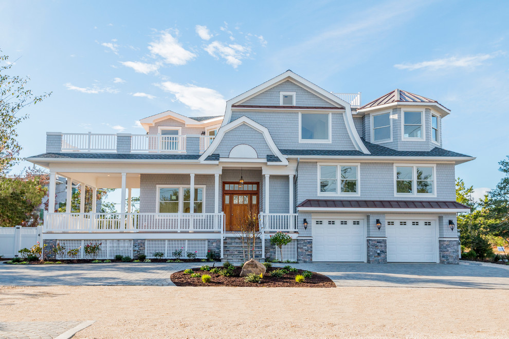 Example of a beach style blue wood exterior home design in New York with a gambrel roof