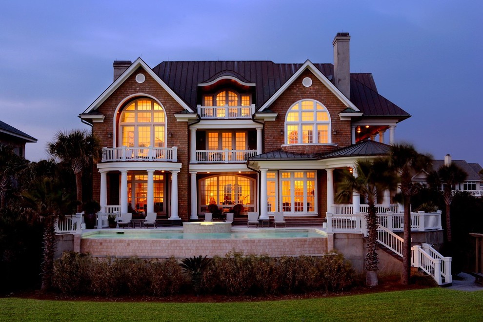 Cette image montre une grande façade de maison marron marine en bois à deux étages et plus avec un toit à deux pans.