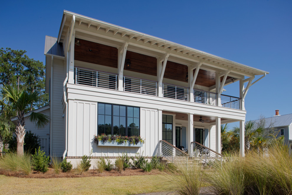 Imagen de fachada de casa blanca costera de dos plantas con tejado de metal