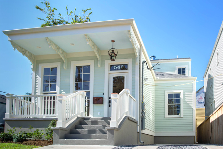 На фото: маленький, одноэтажный, деревянный, синий дом в викторианском стиле с вальмовой крышей для на участке и в саду
