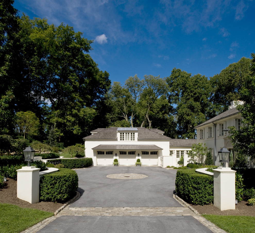 Huge elegant white two-story stucco exterior home photo in Philadelphia with a clipped gable roof