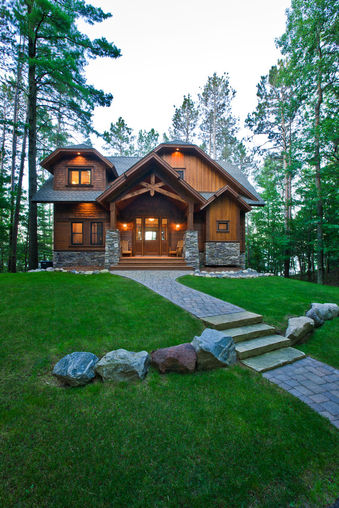 Inspiration pour une façade de maison marron chalet en bois de taille moyenne et à un étage avec un toit à croupette.