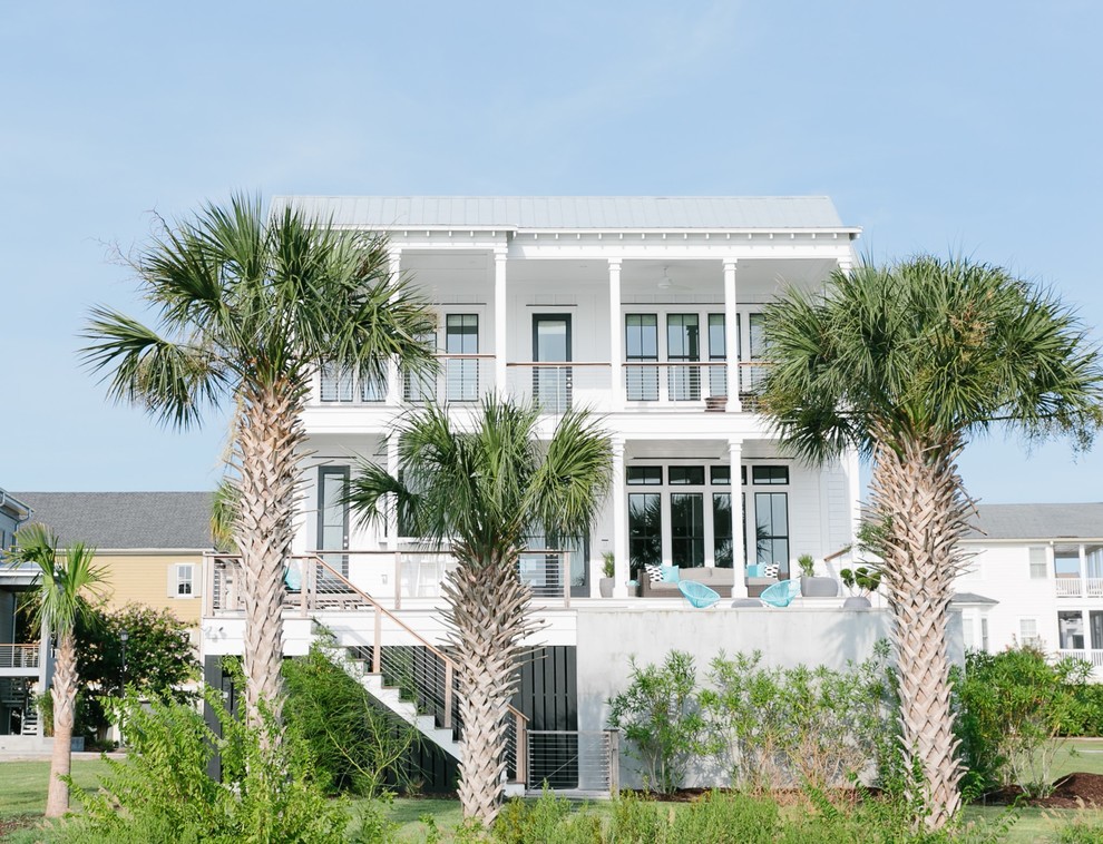 Foto della facciata di una casa bianca tropicale a due piani con rivestimento con lastre in cemento