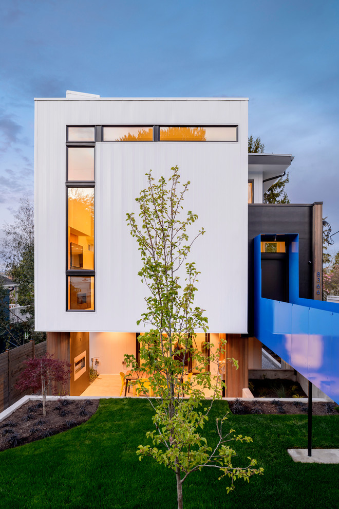 Bild på ett mellanstort funkis flerfärgat hus, med tre eller fler plan, metallfasad och platt tak