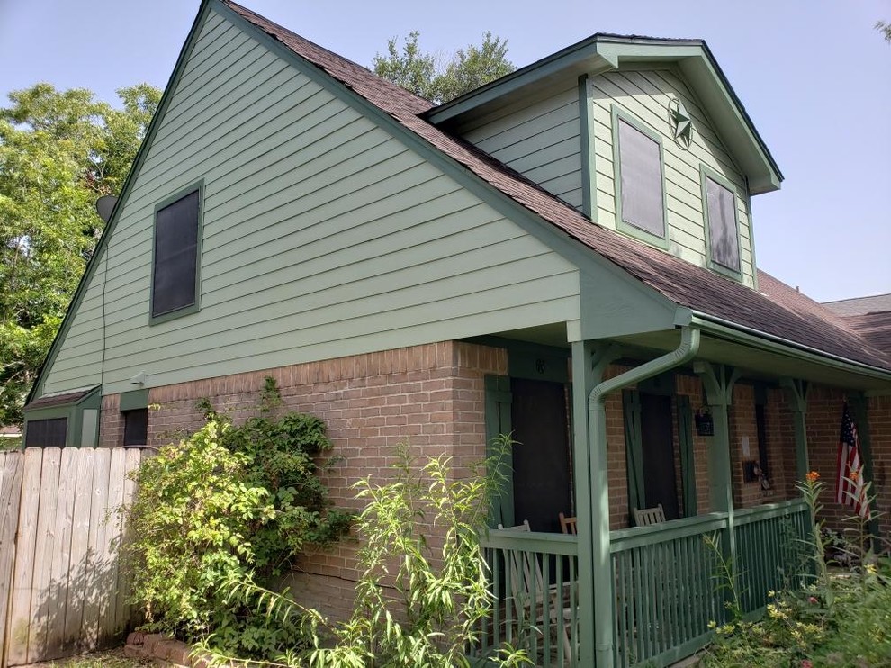 Exemple d'une façade de maison verte chic en bois de taille moyenne et à un étage avec un toit à deux pans et un toit en shingle.
