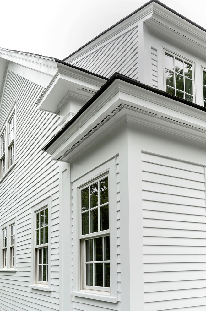 Foto de fachada blanca de estilo de casa de campo de tamaño medio de dos plantas con revestimiento de madera y tejado a dos aguas