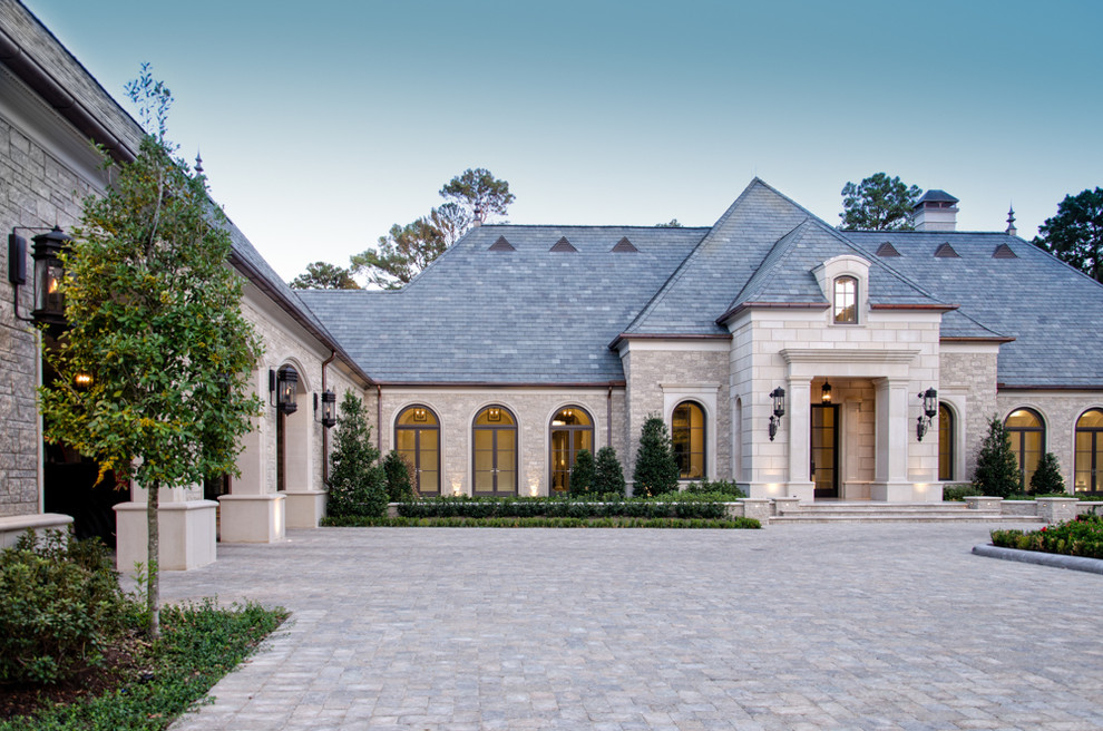 Design ideas for an expansive and beige mediterranean house exterior in Houston with stone cladding and a pitched roof.