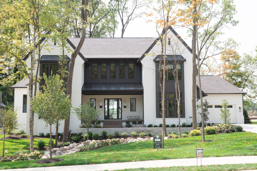 Ispirazione per la facciata di una casa beige moderna a due piani di medie dimensioni con rivestimento in metallo e falda a timpano