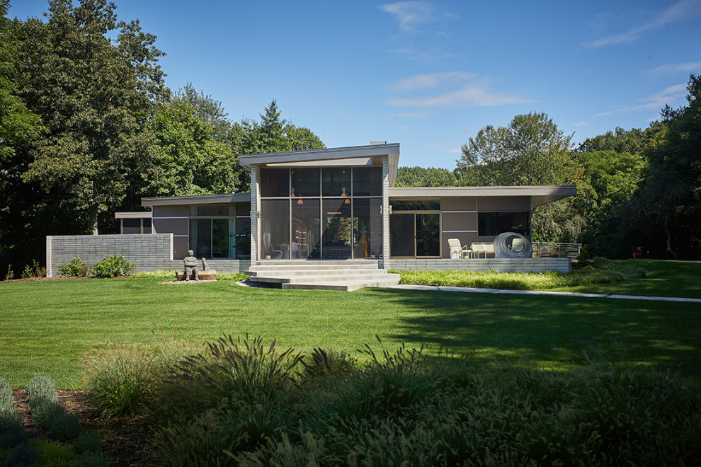 На фото: коричневый частный загородный дом в стиле модернизм с односкатной крышей