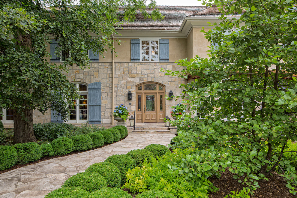 Traditional beige two-story stone exterior home idea in Omaha