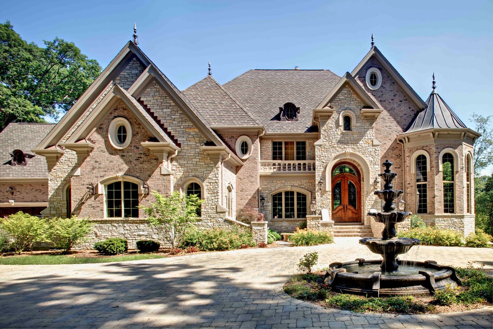 Large elegant beige two-story brick exterior home photo in Chicago with a shingle roof