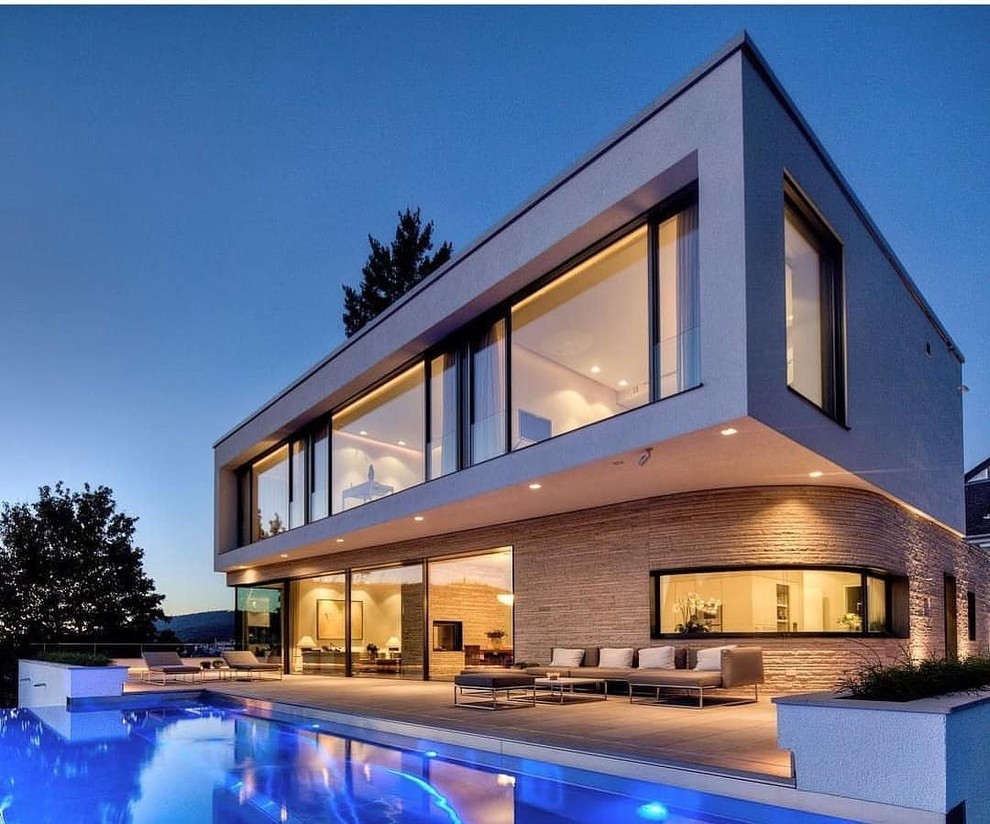 Modelo de fachada de casa minimalista grande de dos plantas con revestimientos combinados y tejado a cuatro aguas