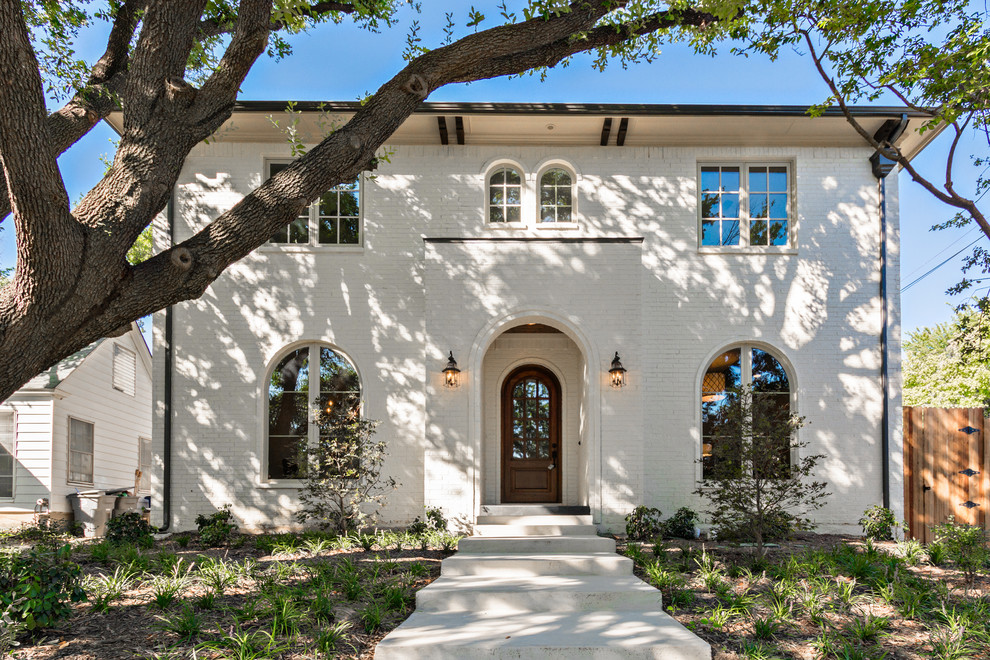 Example of a classic white two-story brick exterior home design in Dallas