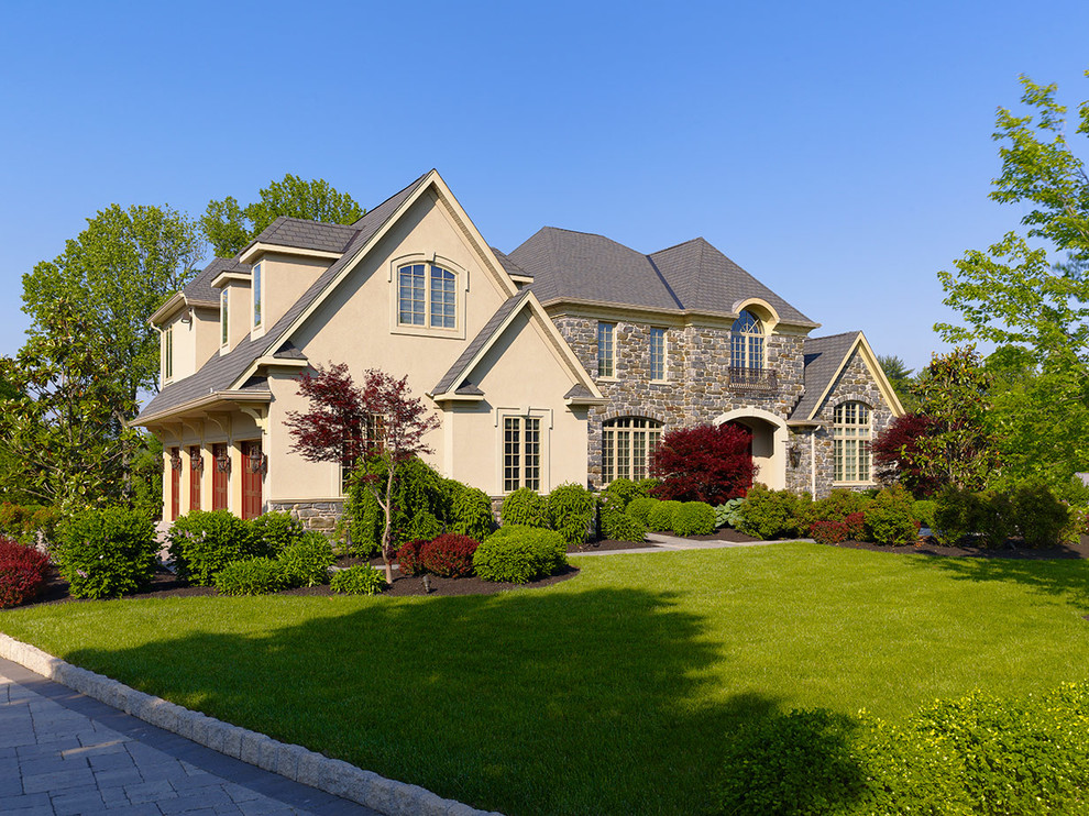 Example of a huge transitional beige two-story stone exterior home design in Philadelphia