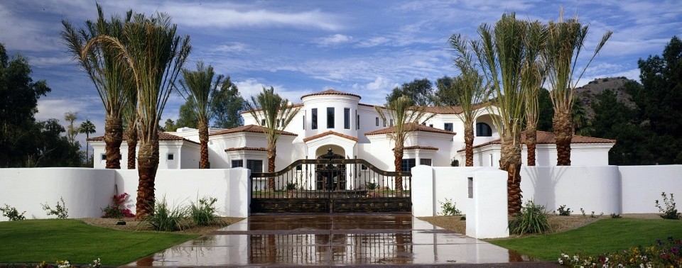 На фото: большой, белый дом в стиле фьюжн с облицовкой из самана с