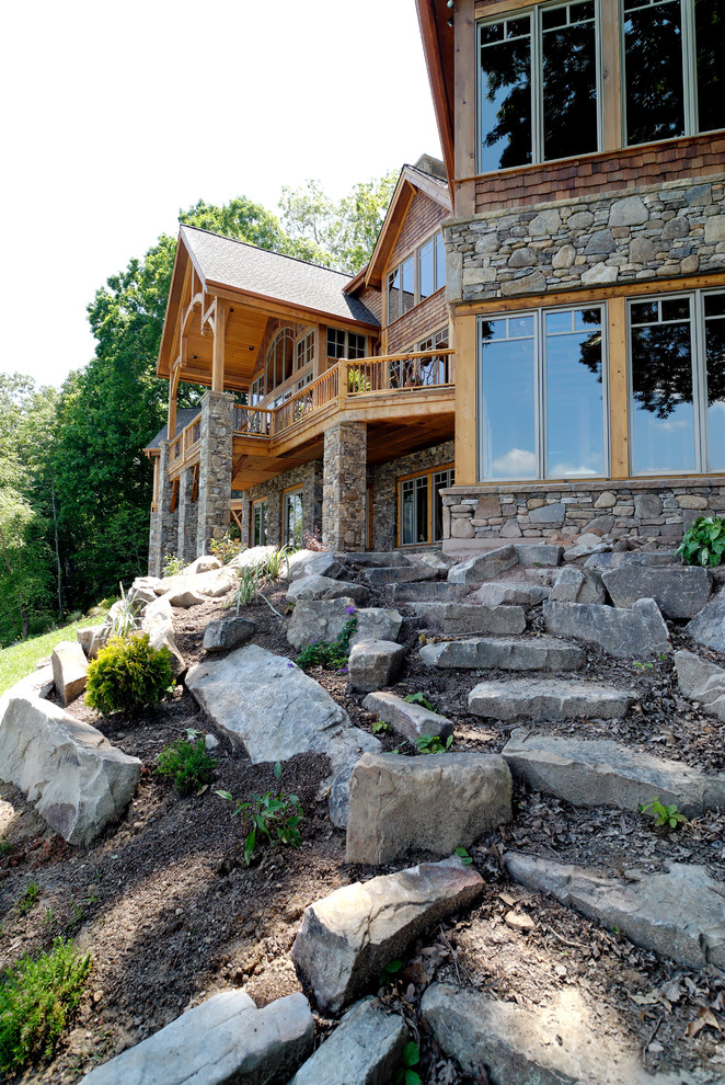 Cette photo montre une grande façade de maison montagne en bois à un étage.