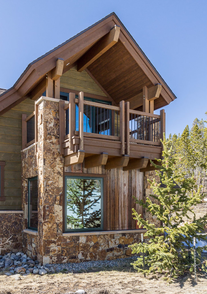 Idées déco pour une grande façade de maison verte montagne en bois à un étage.