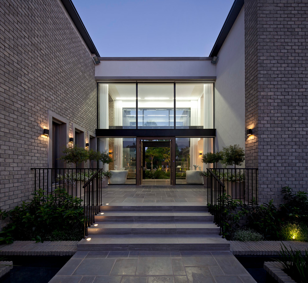 Inspiration pour une grande façade de maison blanche minimaliste en brique à un étage.