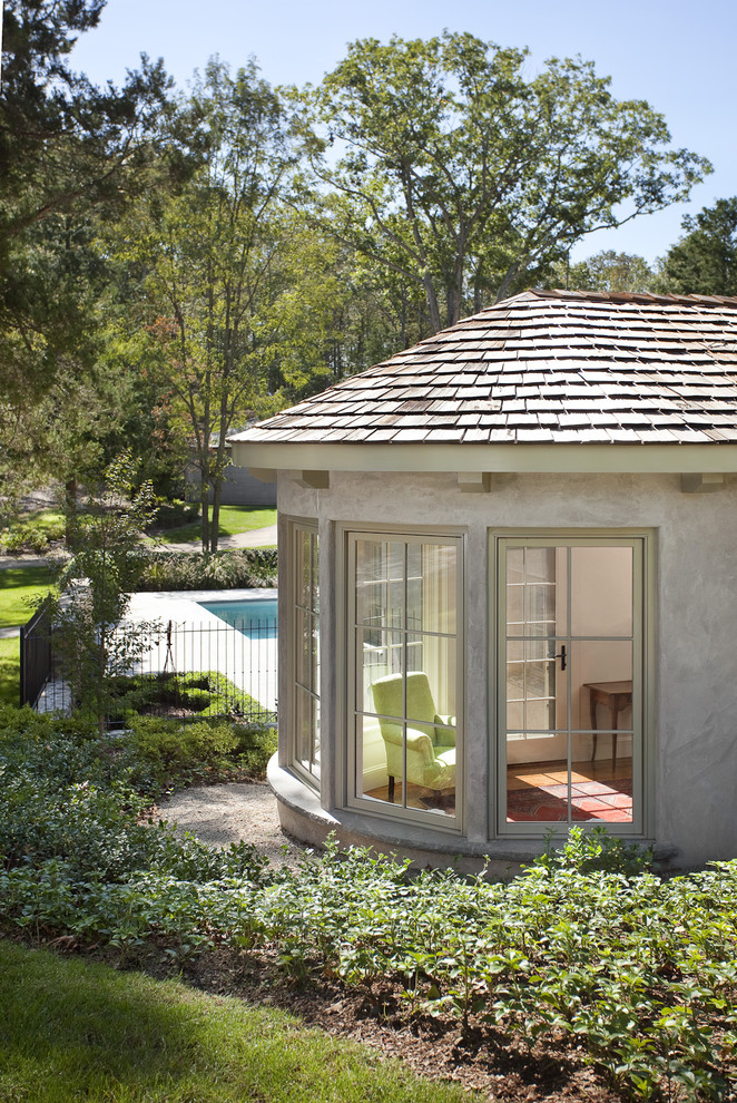 Diseño de fachada de casa beige mediterránea de tamaño medio de dos plantas con revestimiento de hormigón, tejado a cuatro aguas y tejado de teja de madera