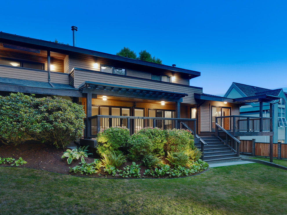 На фото: двухэтажный, деревянный, коричневый дом среднего размера в современном стиле с односкатной крышей с