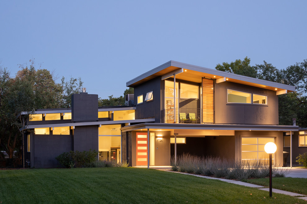 На фото: деревянный, серый частный загородный дом среднего размера в стиле ретро с разными уровнями с