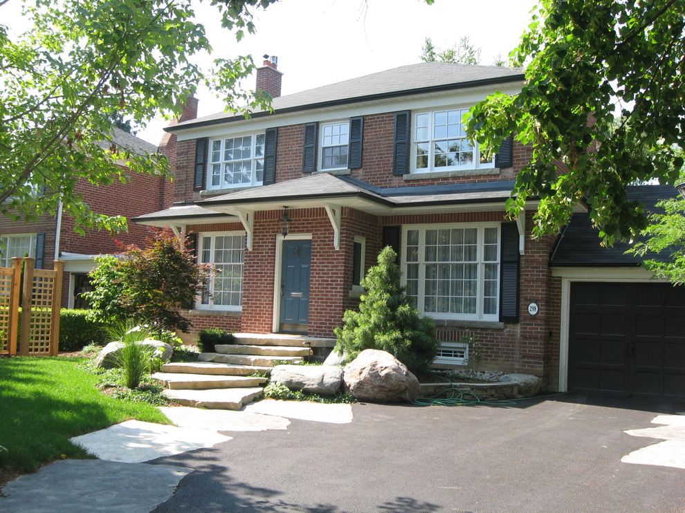 Mid-sized traditional brown two-story brick exterior home idea in Toronto with a hip roof
